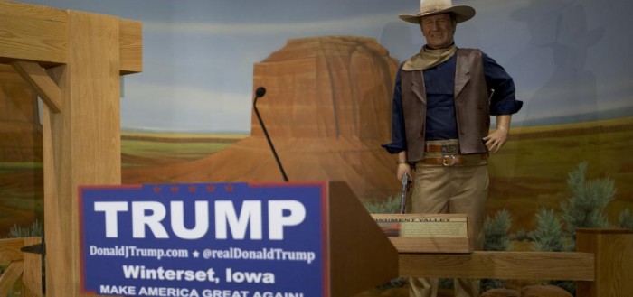 A podium for Republican presidential candidate Donald Trump stands in front of a wax statue of John Wayne at the John Wayne Museum Tuesday, Jan. 19, 2016, in Winterset, Iowa. Trump is scheduled to speak at the museum. (AP Photo/Jae C. Hong)